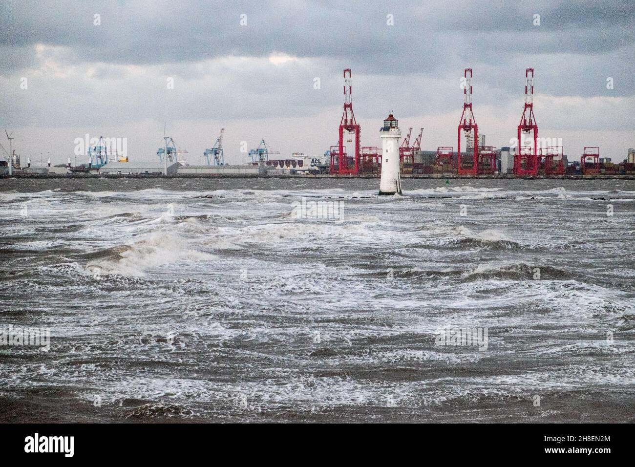Liverpool, UK. 26th Nov, 2021. Photo taken from New Brighton of gale force winds blowing with rough seas.Lighthouse at New Brighton and Liverpool waterfront in background. Stock Photo