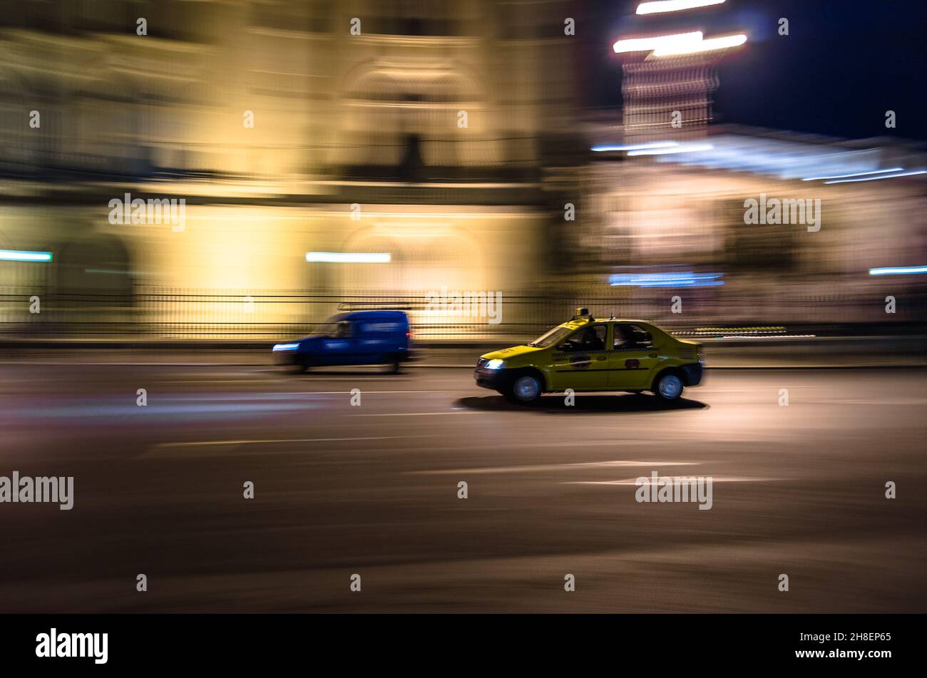 BUCHAREST, ROMANIA - NOVEMBER 17, 2013: Taxi in motion, at night in Bucharest, Romania, panning efect Stock Photo