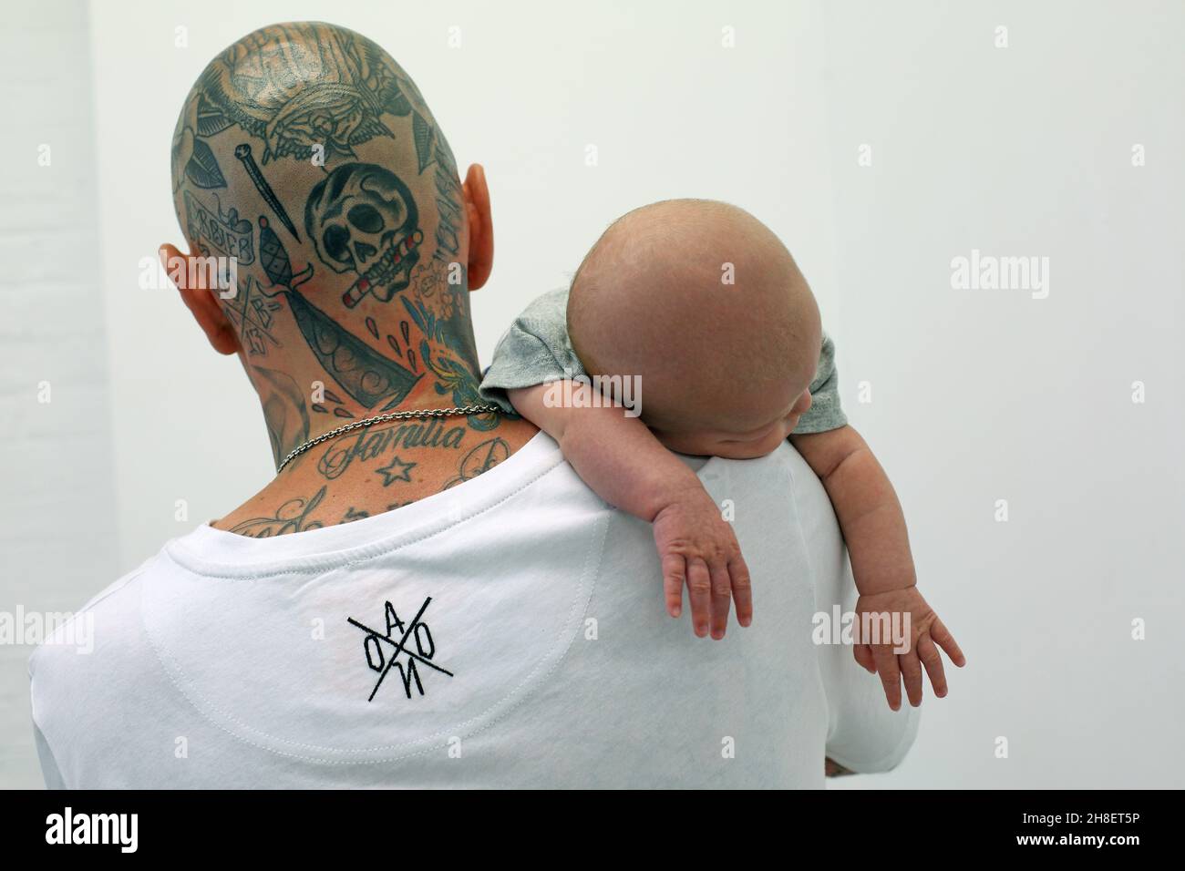 Father with tattoos holds his newborn son Stock Photo