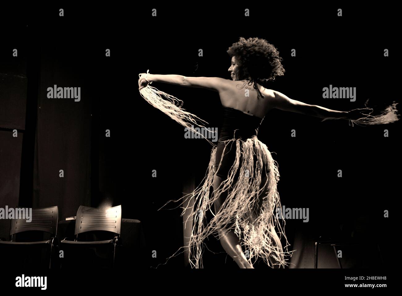 Portrait of a woman dancing on stage against black background. Salvador, Bahia, Brazil. Stock Photo