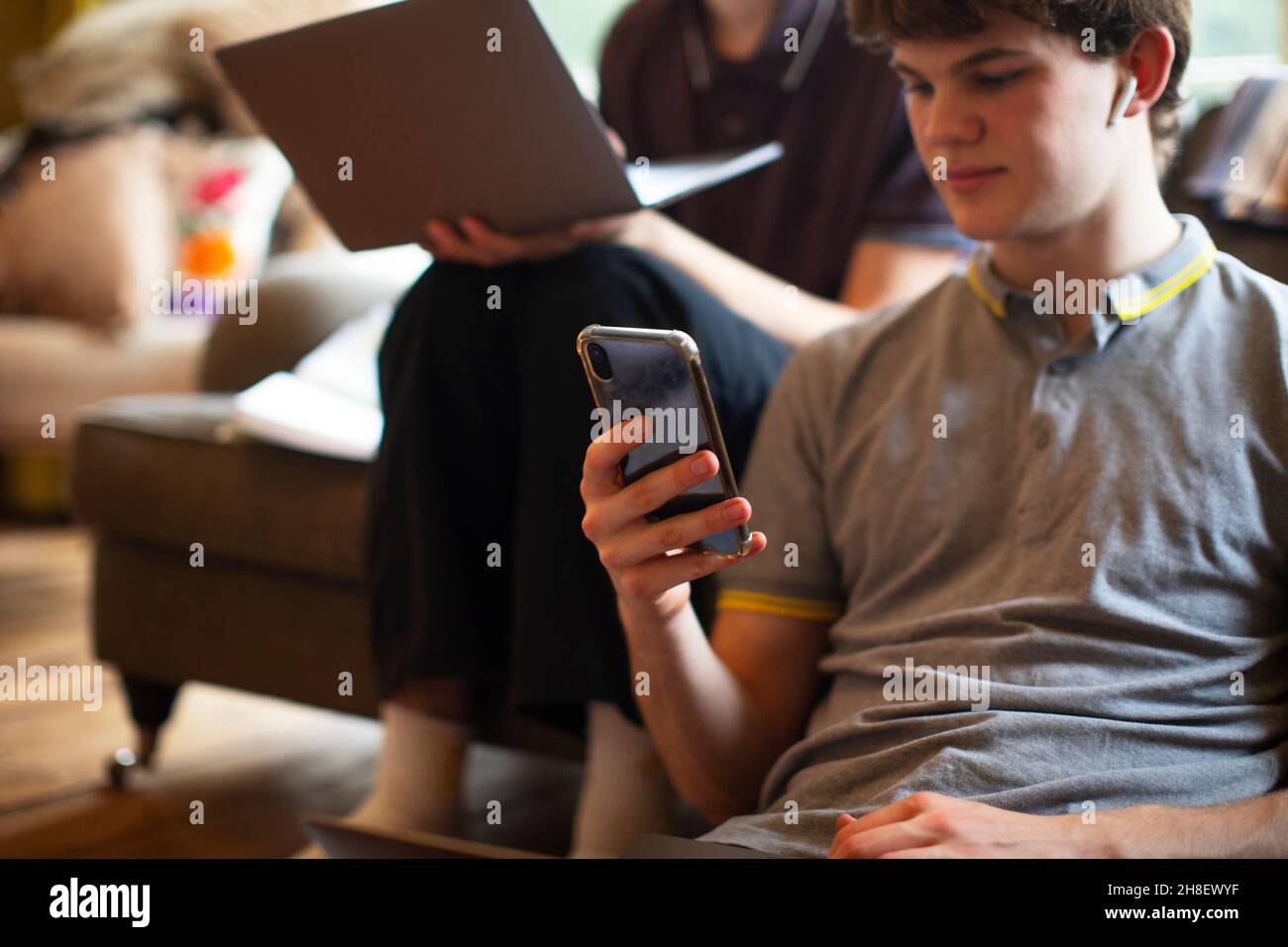 Teenage boy using smart phone at home Stock Photo - Alamy