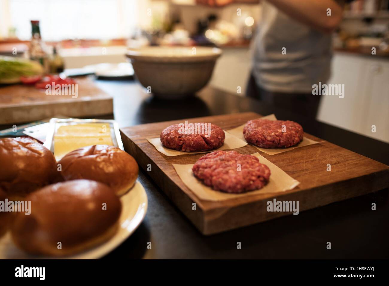 Close up fresh hamburger patties and buns on kitchen counter Stock Photo