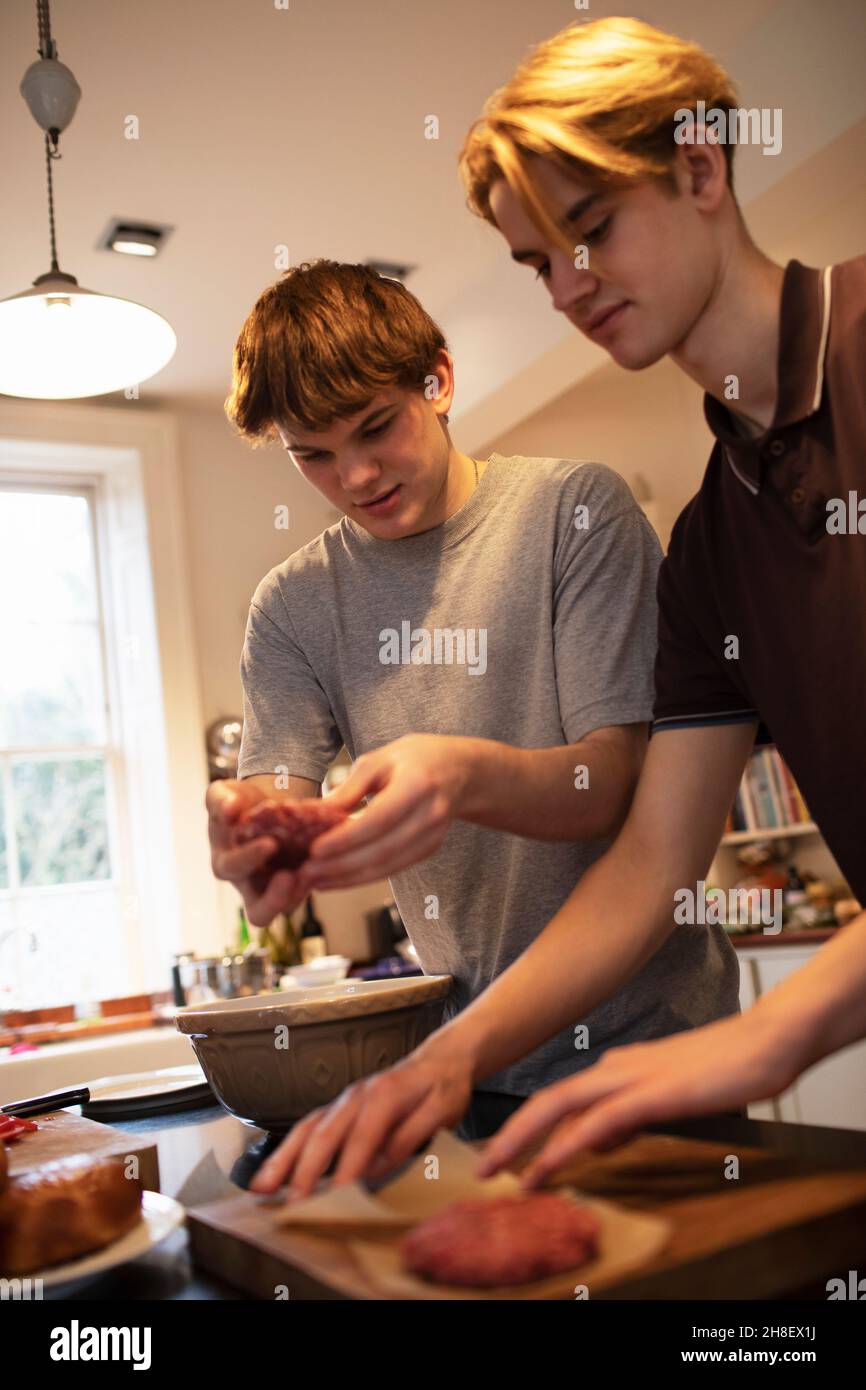 Teenage boys making hamburger patties in kitchen Stock Photo - Alamy