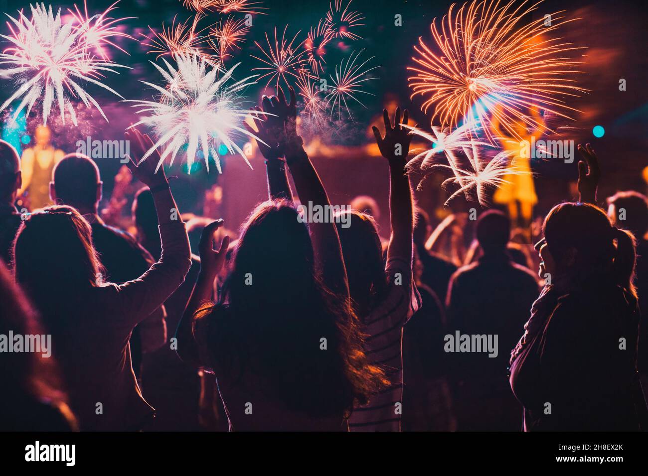 Cheering crowd watching fireworks at New Year Stock Photo
