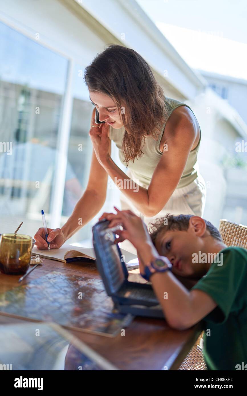 Mother and son working and studying at dining table Stock Photo