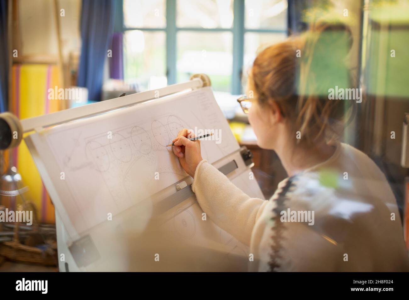Female architect drafting blueprints in home office Stock Photo