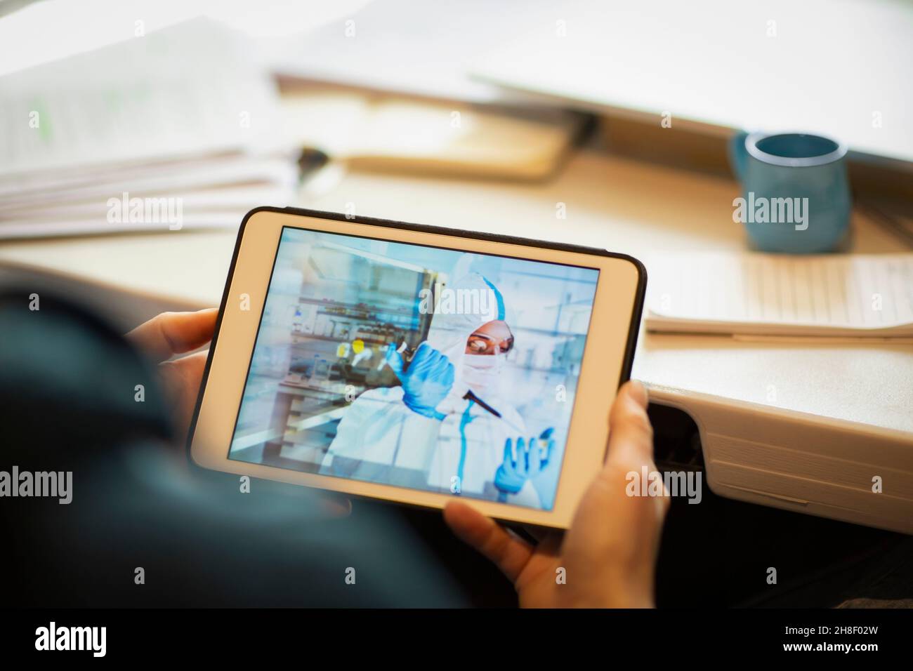 Man watching scientist with pipette on digital tablet screen Stock Photo