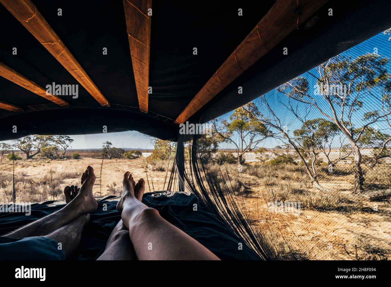 POV carefree couple relaxing in tent in remote landscape, Australia