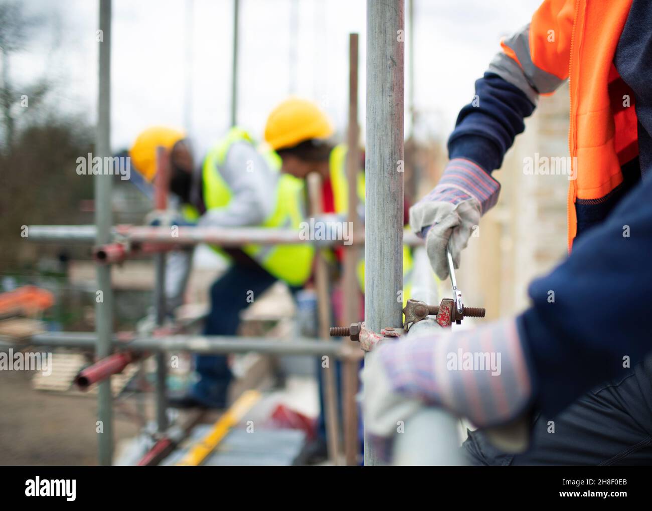 Construction workers assembling scaffolding at construction site Stock