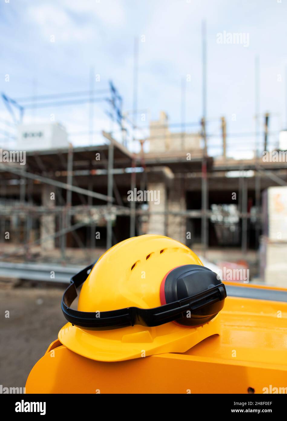 Still life hard hat with ear protectors at construction site Stock Photo