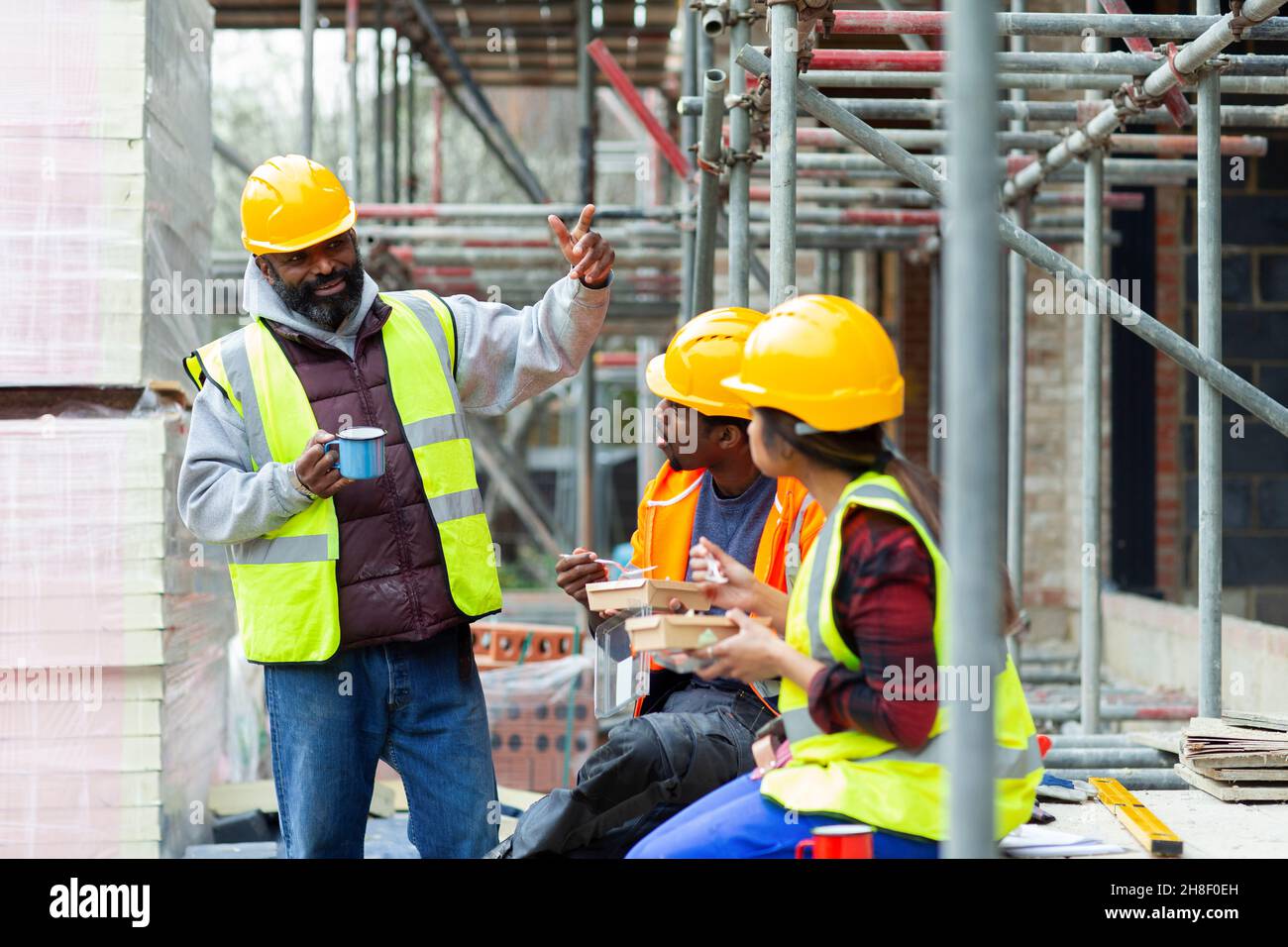Construction workers enjoying lunch break at construction site Stock