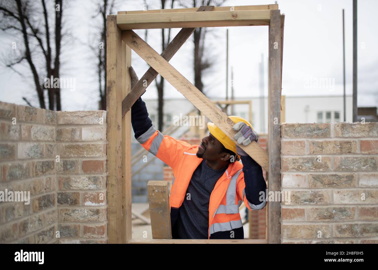 Male construction worker installing door frame at construction site Stock Photo