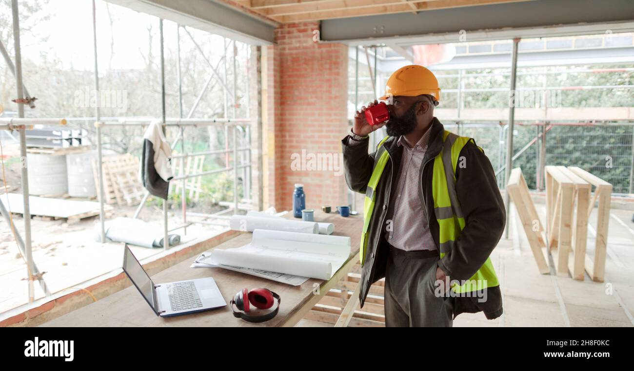 Male architect drinking coffee at construction site Stock Photo