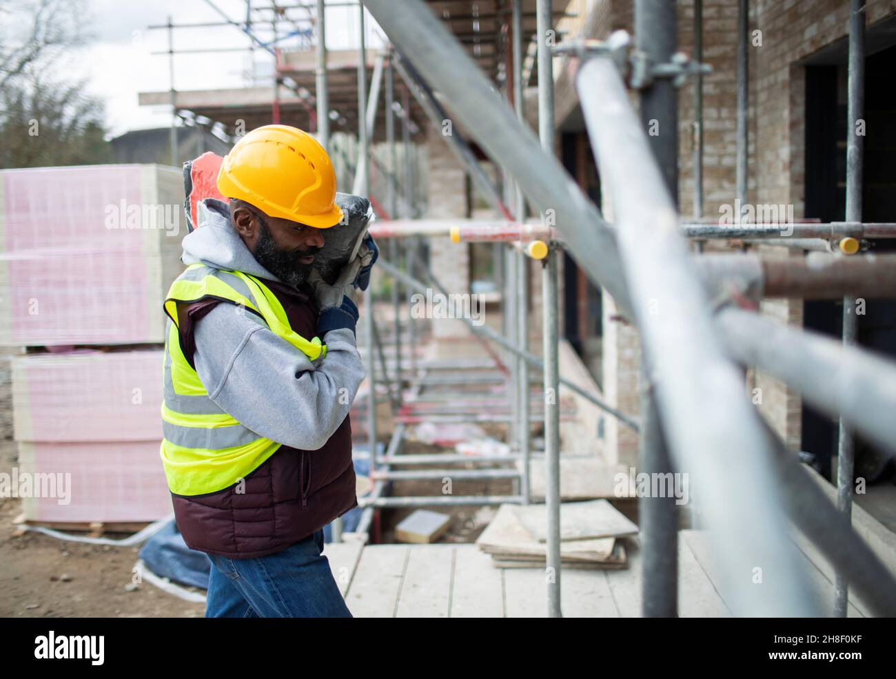Male construction worker carrying equipment at construction site Stock Photo
