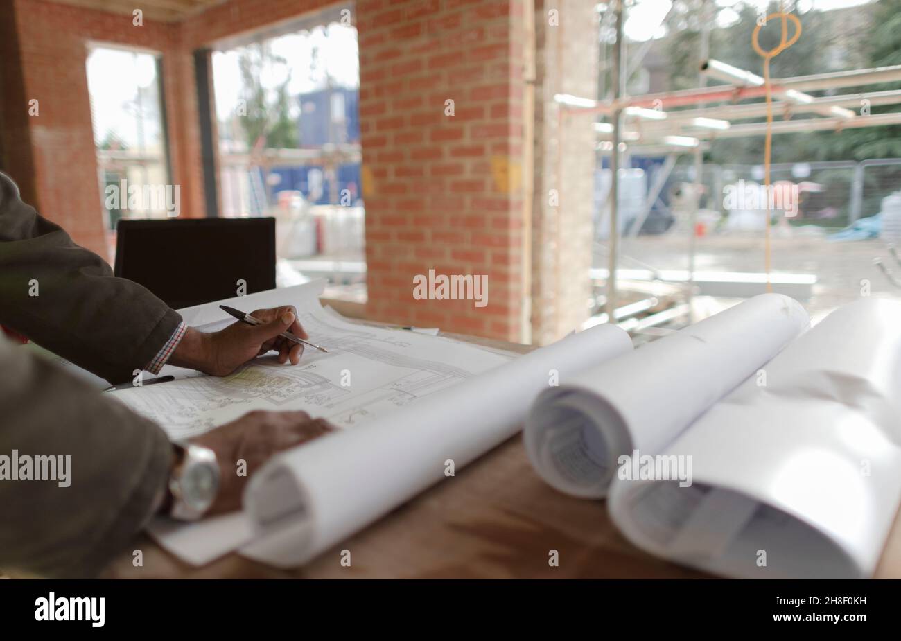 Architect reviewing blueprints at construction site Stock Photo