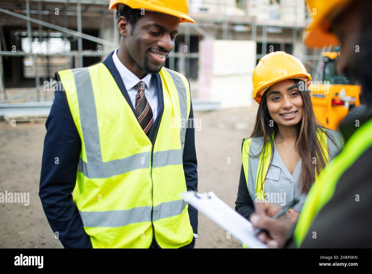 Architects and foreman talking at construction site Stock Photo