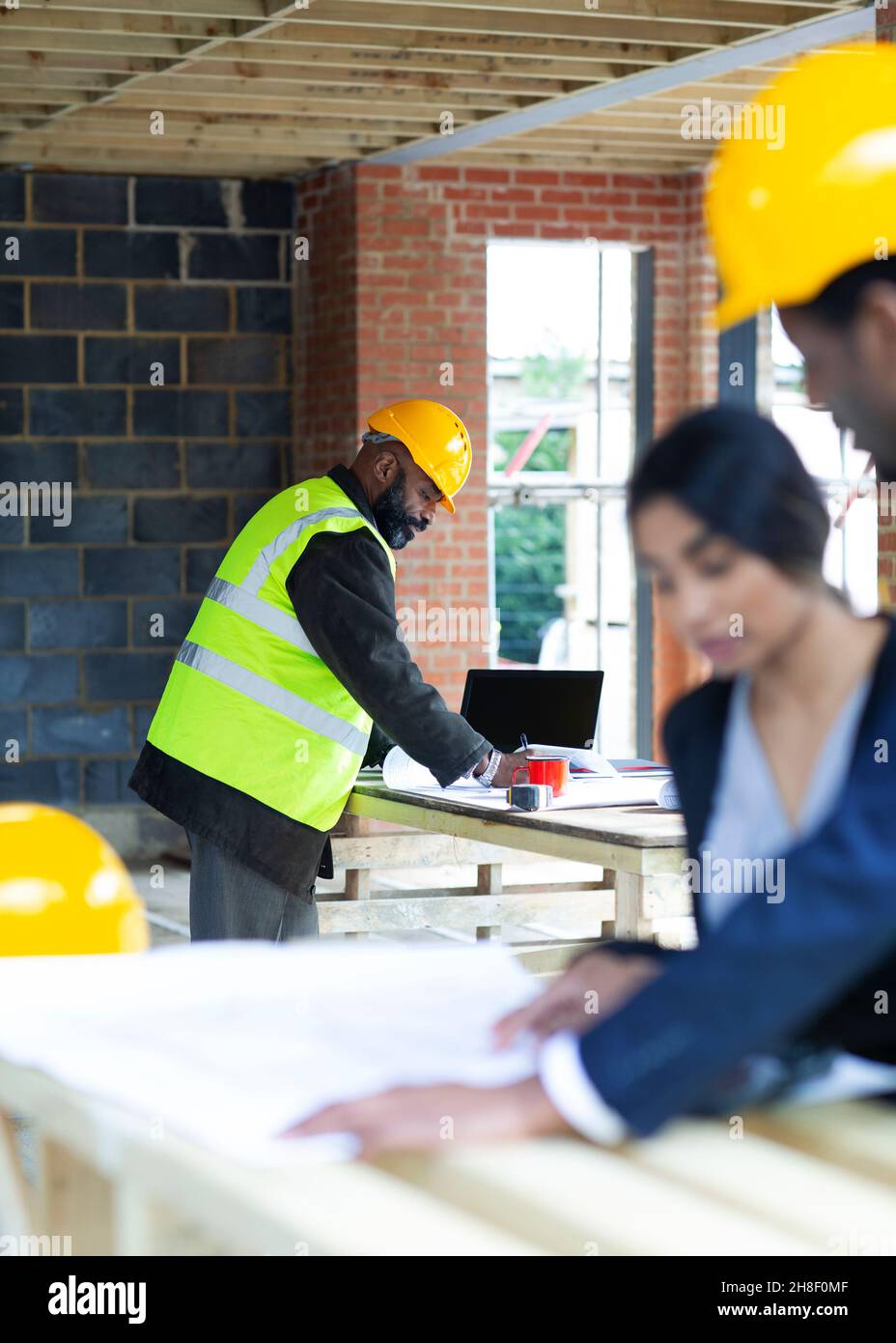 Architects reviewing blueprints at construction site Stock Photo