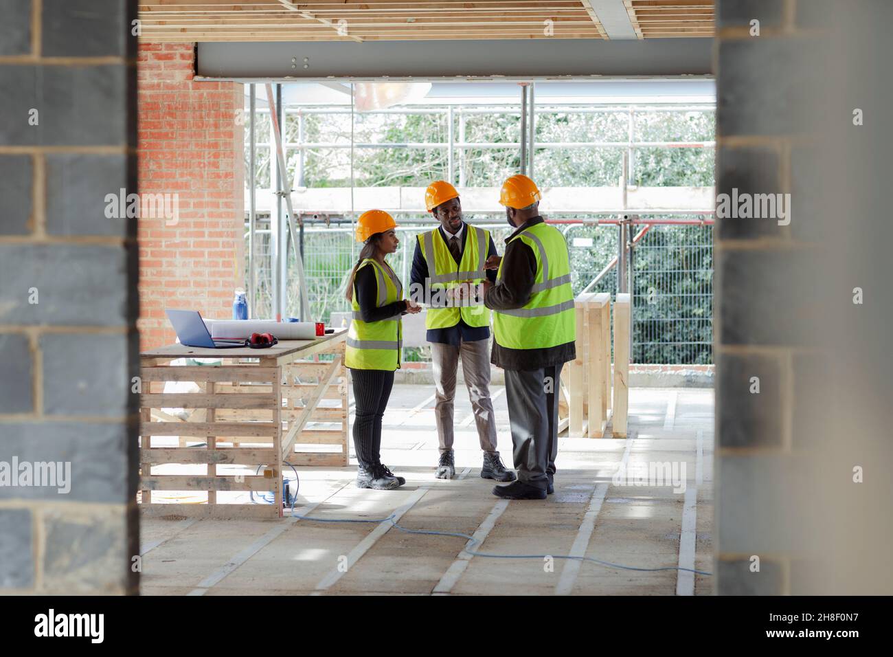 Architects and engineer talking at construction site Stock Photo