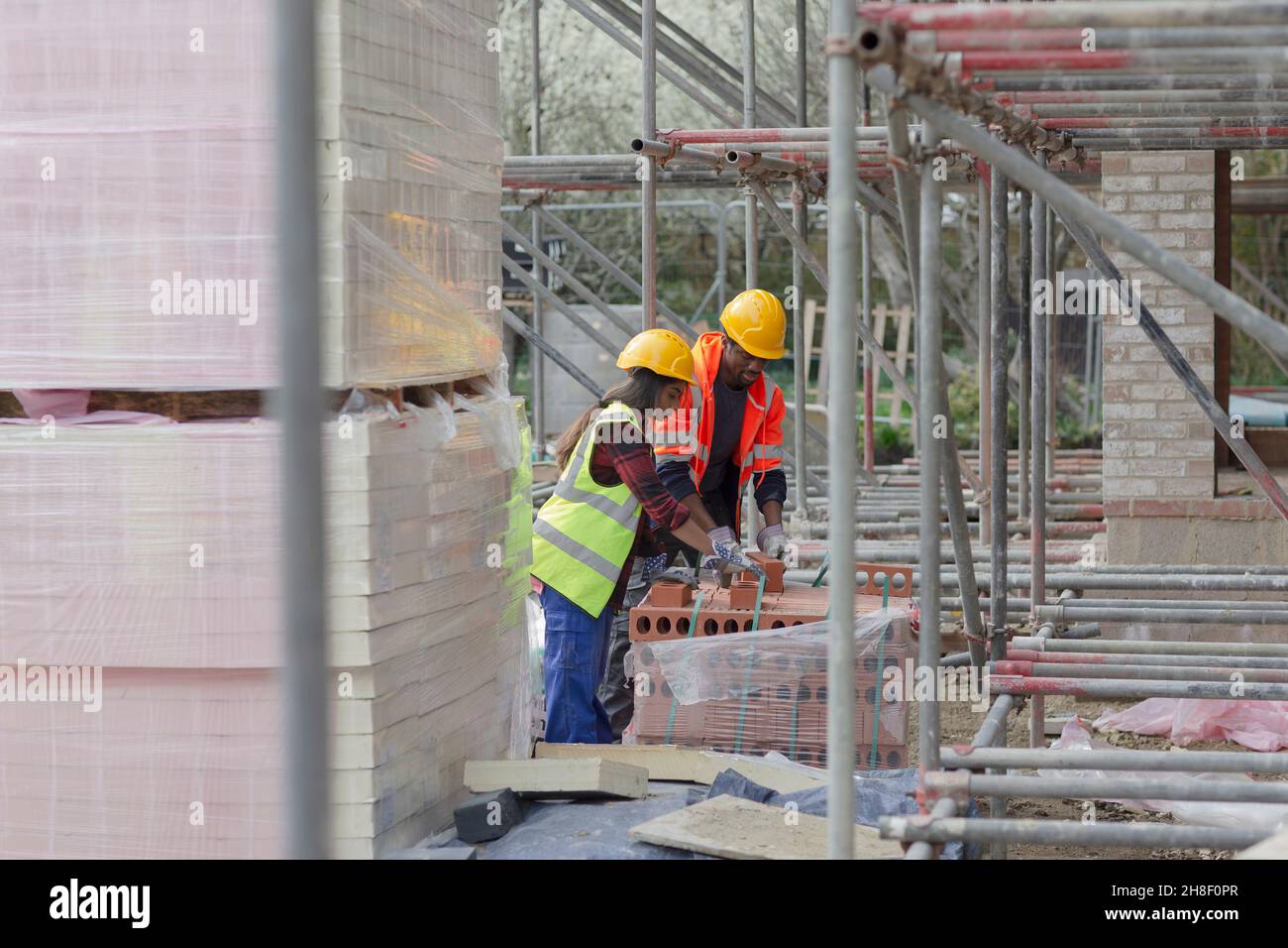 Construction workers with brick at construction site Stock Photo
