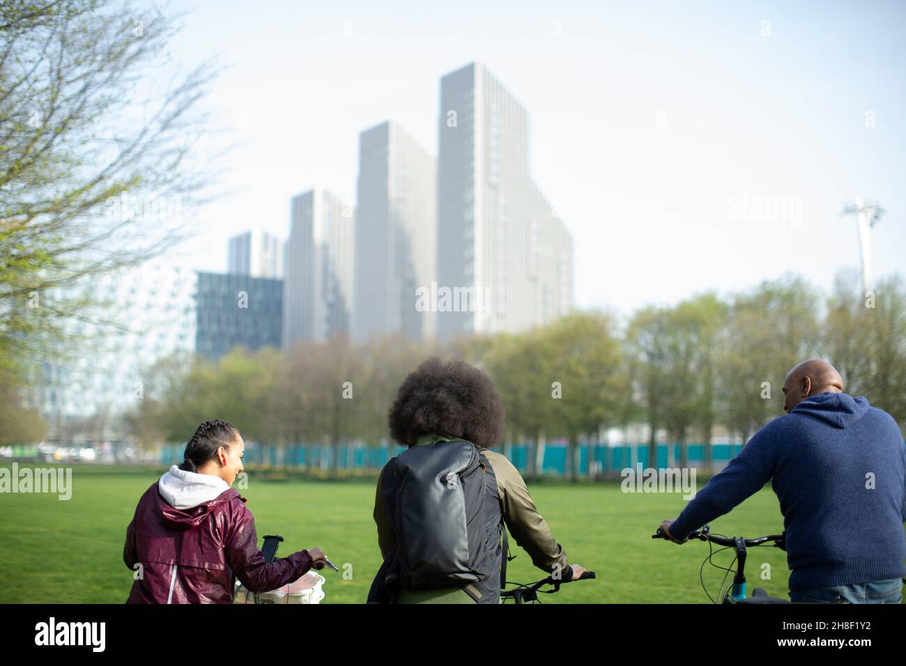 Father and teen kids with bicycles in city park, London, UK Stock Photo