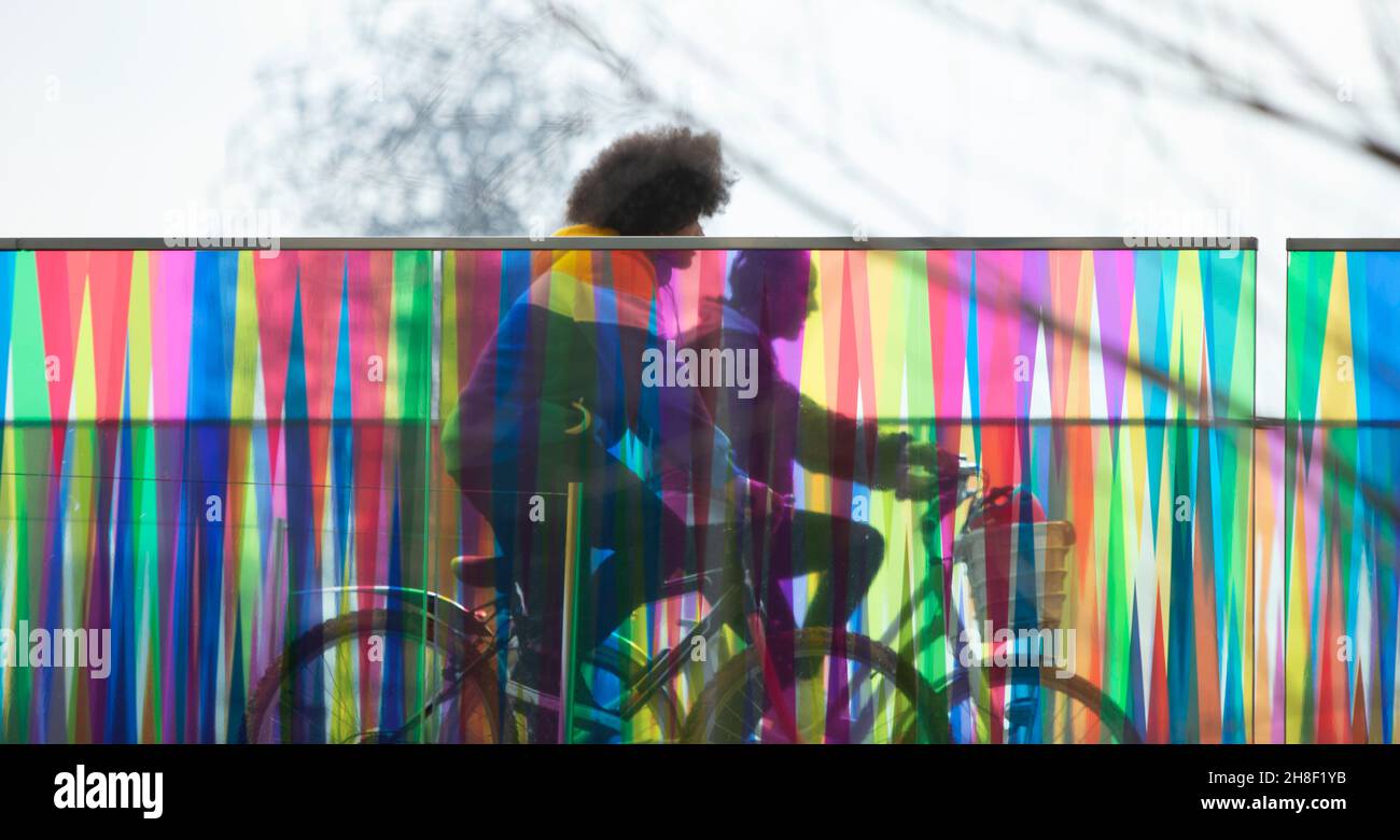 Teenagers riding bicycles on modern bridge Stock Photo