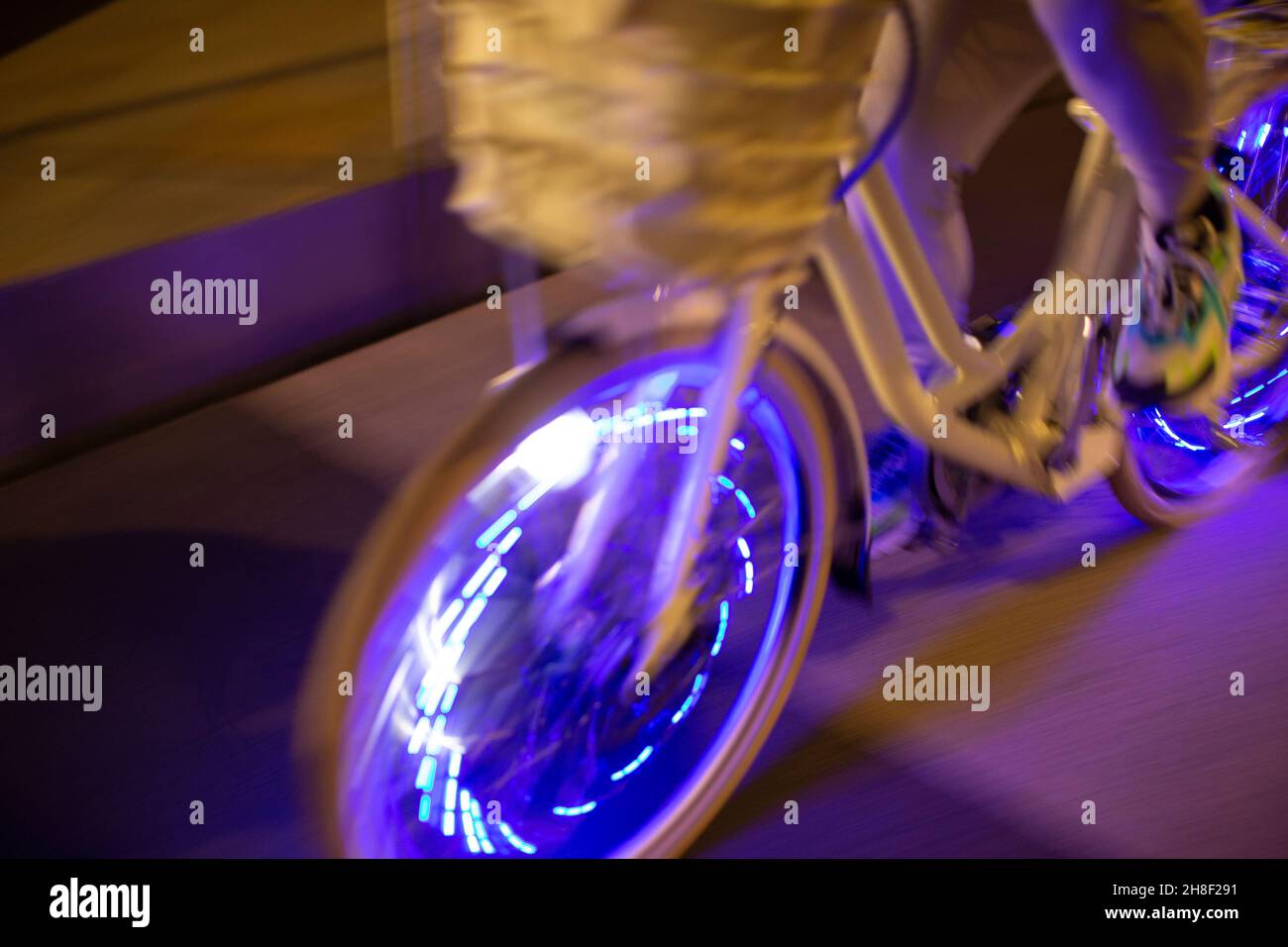 Man riding bicycle with purple lights at night Stock Photo Alamy