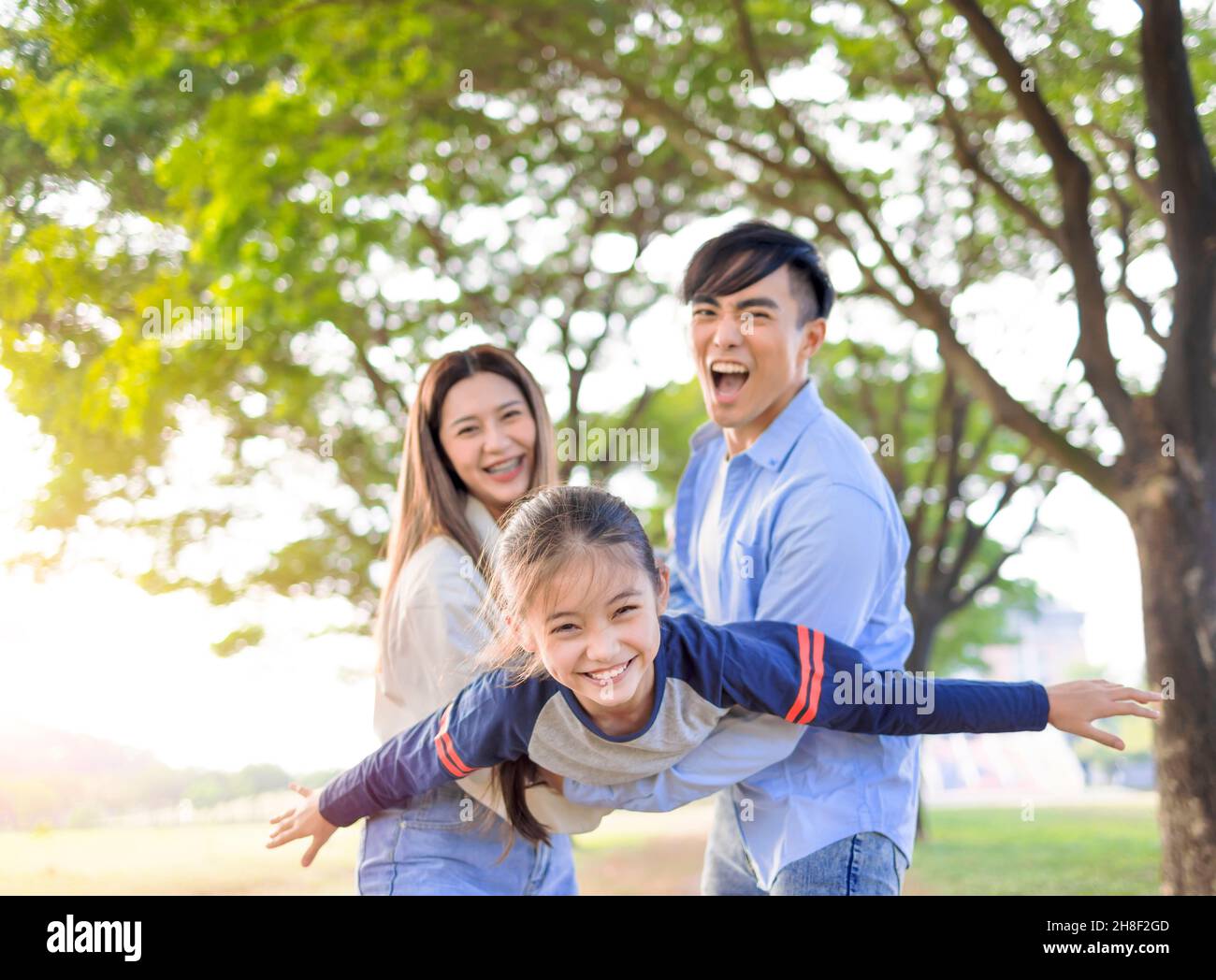 Happy Family with daughter playing together in the park Stock Photo
