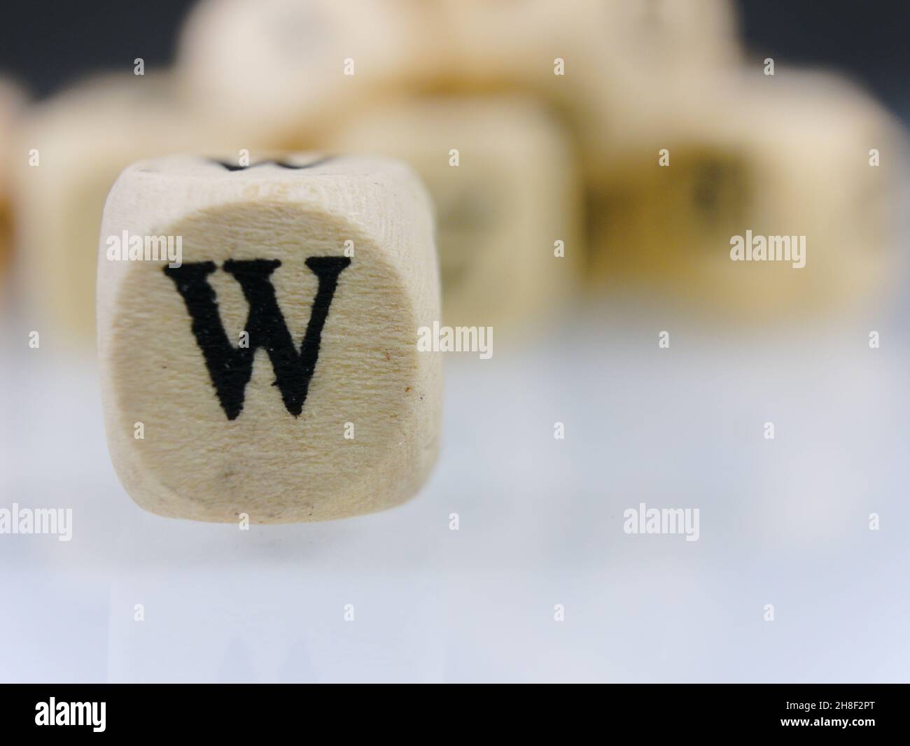 Selective focus shot of the letter W on a wooden dice Stock Photo