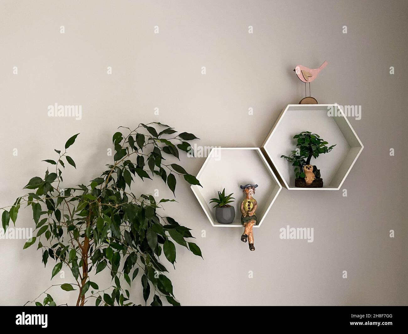 Decorative wooden, floating, hexagon wall shelves on beige wa Stock Photo