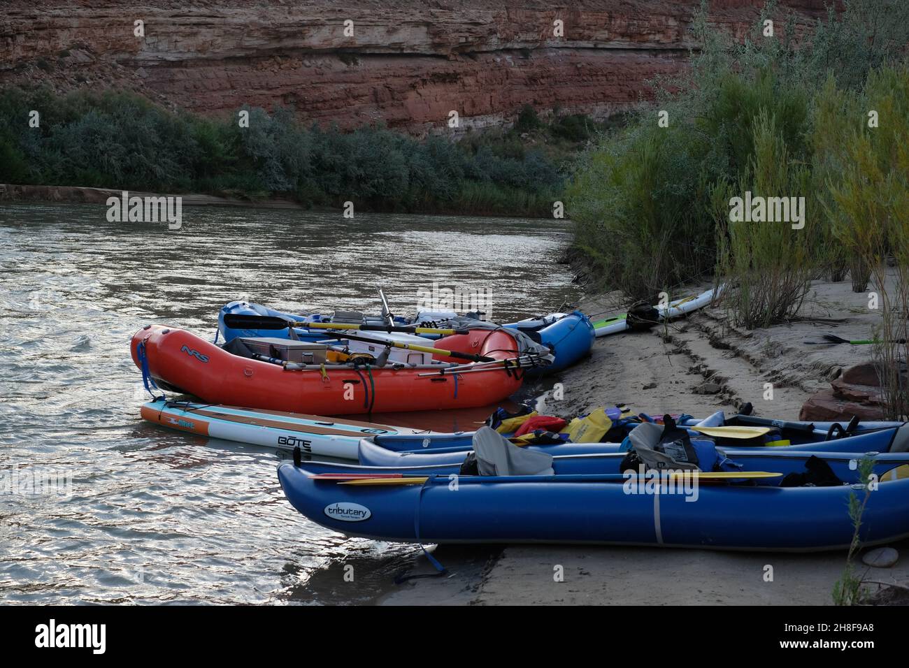 White water rafts and inflatable kayaks parked on the San Juan River at ...
