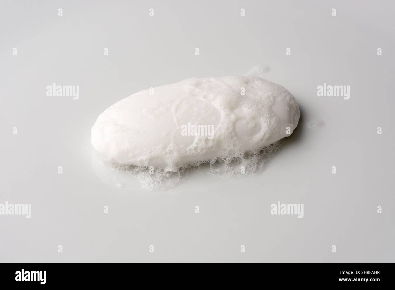 white soap with foam, isolated on a neutral gray background, mockup template for graphic designing Stock Photo
