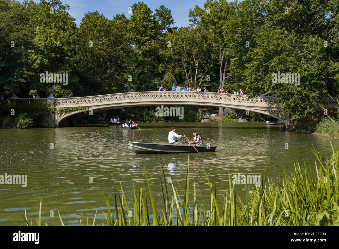 NEW YORK CITY - JUNE 28, 2014: View of the Bow Bridge with people boating in central park Stock Photo