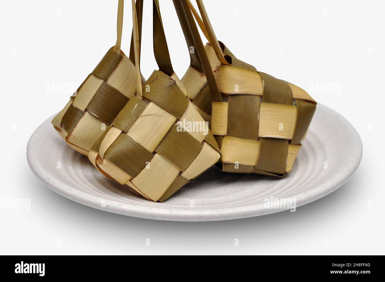 Ketupat is a type of dumpling made from rice packed inside a diamond-shaped container of woven palm leaf pouch. commonly found in Indonesia, Malaysia, Stock Photo