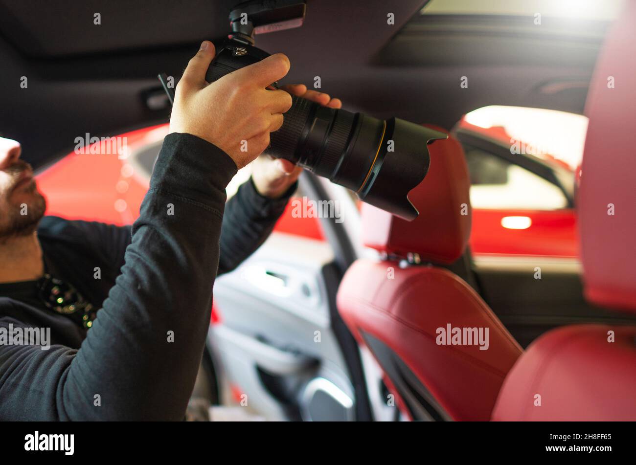 Automotive Professional Photographer with Camera Inside Modern Luxury