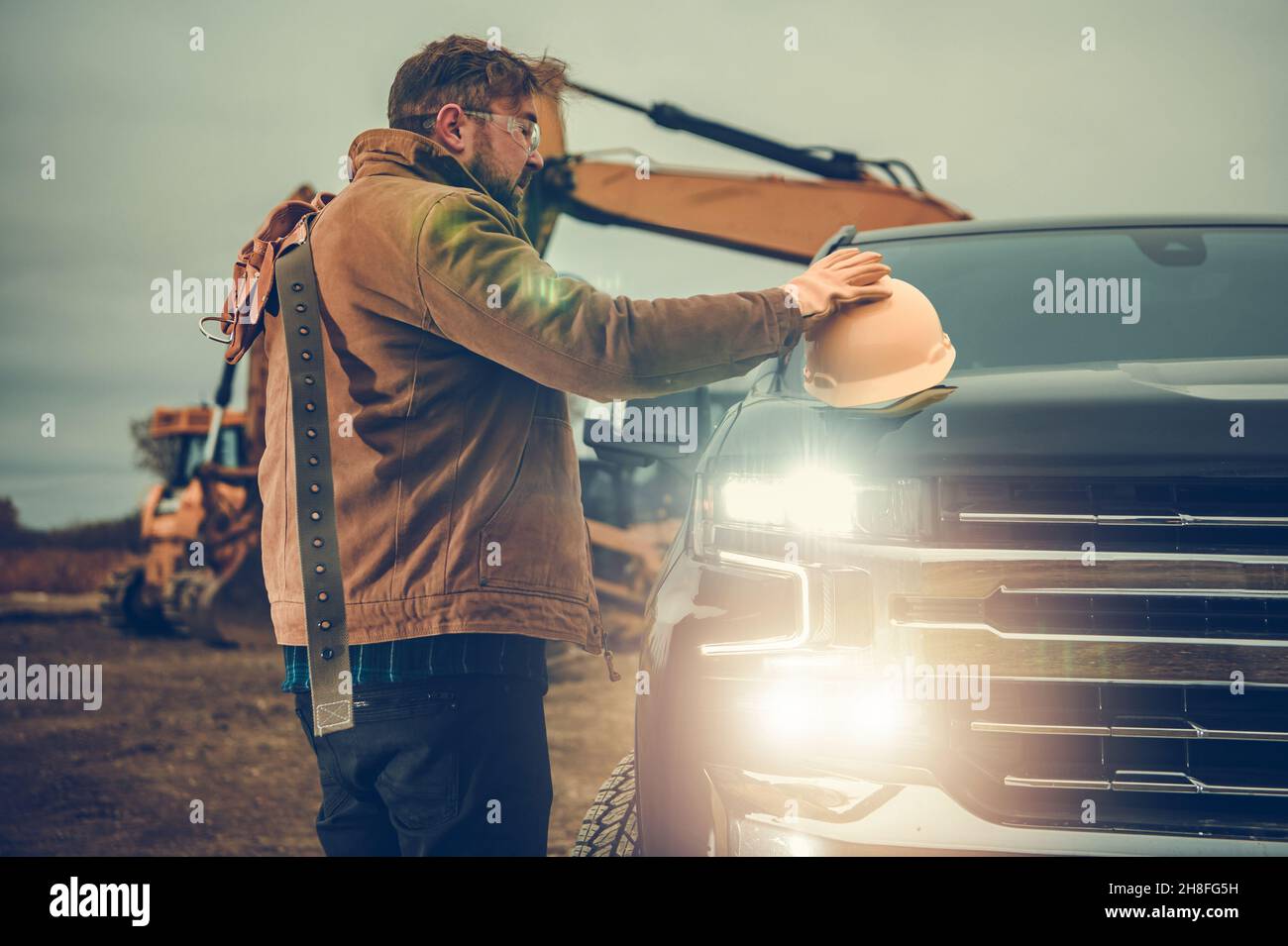 Ground Works Contractor Worker Excavator Operator Next to His Pickup Truck Getting Ready For a Job. Construction Industry Theme. Stock Photo