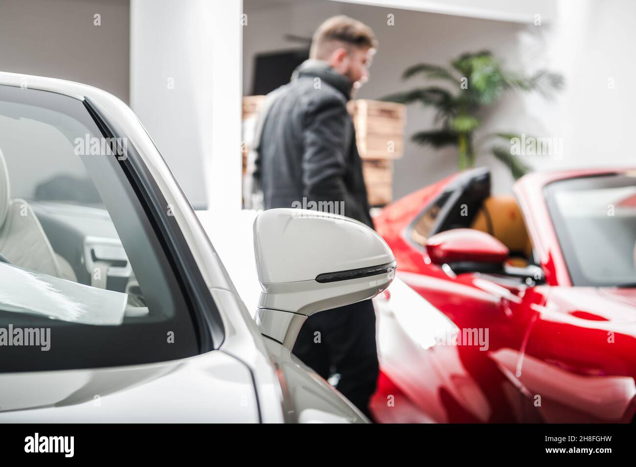 Automotive Industry Theme. New Exotic and Luxury Vehicles Shopping. Caucasian Client Inside Dealership Showroom. Stock Photo