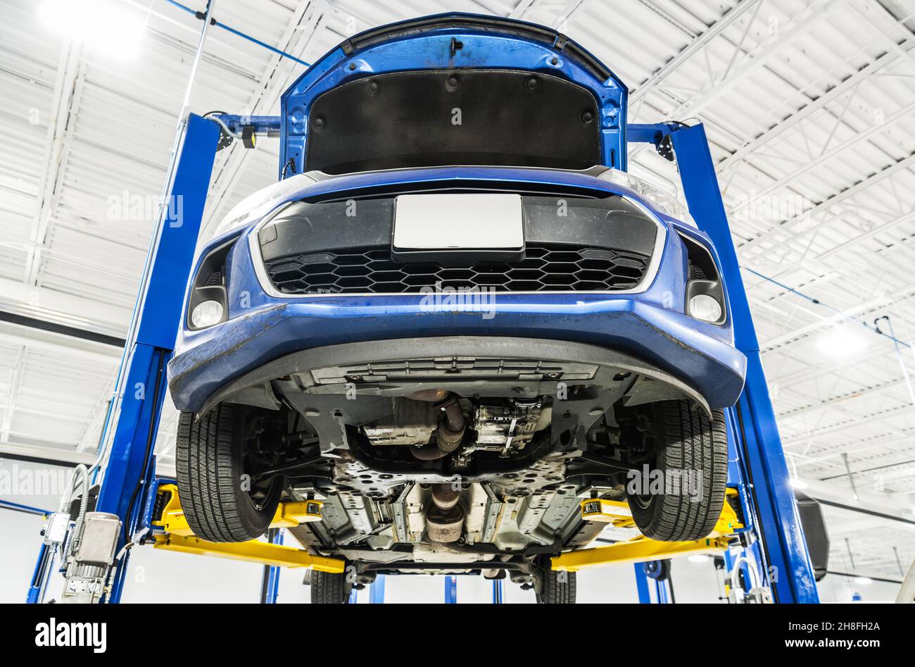 Modern Blue Car on an Automotive Lift During Maintenance. Repair a ...