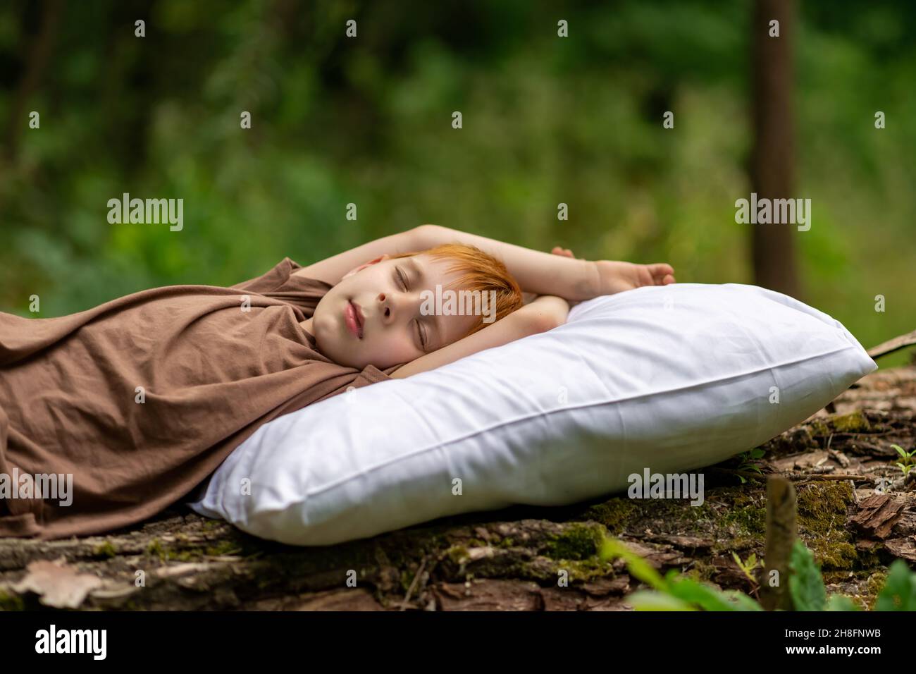 Healthy baby sleep concept. A young boy sleeps on a pillow in the woods