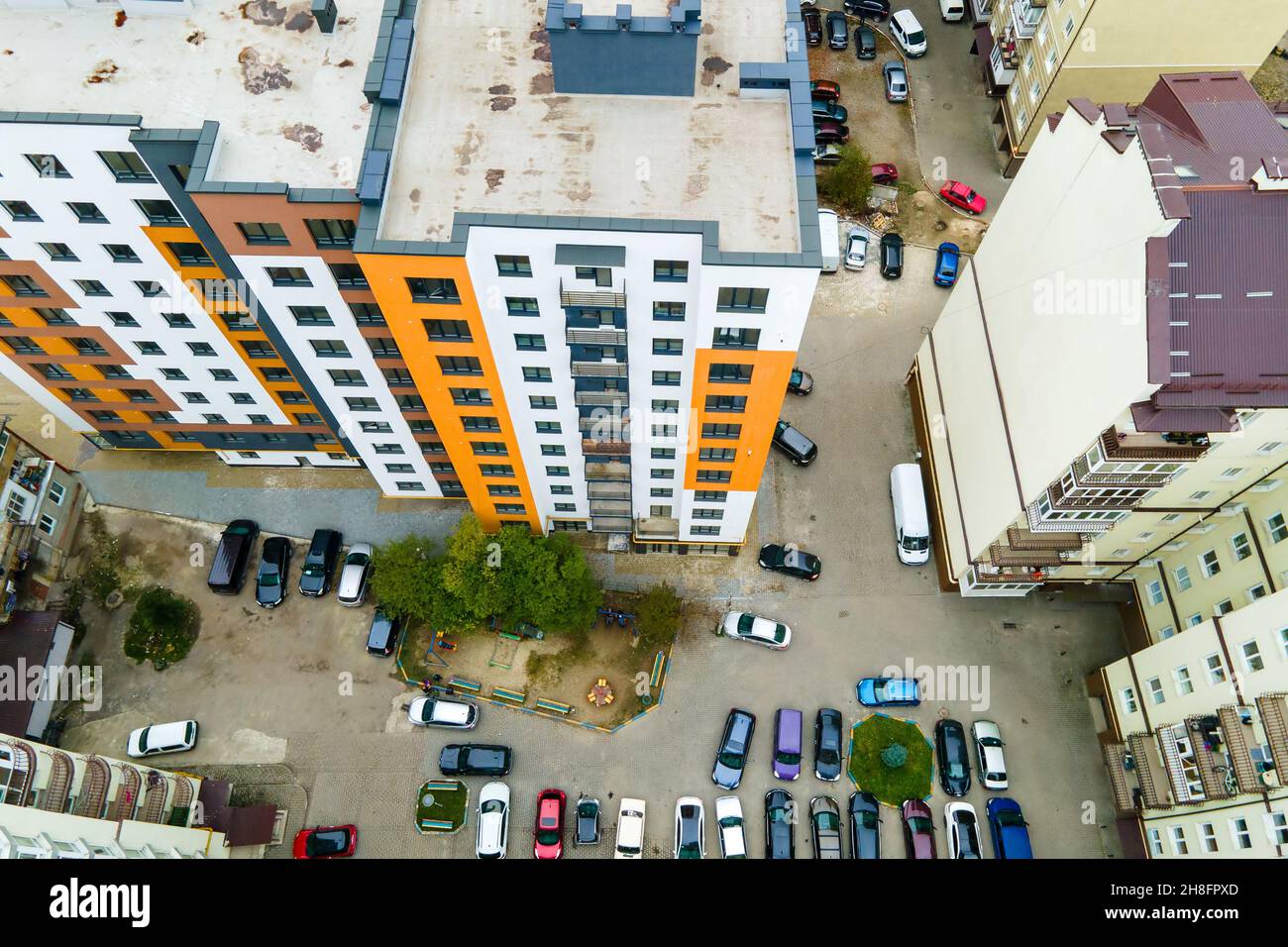 Aerial view of parked cars on parking lot between high apartment ...