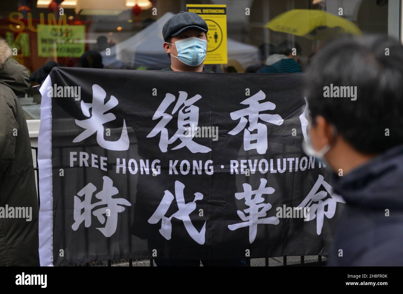 A pro Hong Kong democracy protester holds a Free Hong Kong banner during the counter protest. Dozens of pro democracy, pro Hong Kong independence and anti CCP (Chinese Communist Party) protesters hosted a  counter protest against the Stop Anti-Asian Hate rally 'against the new cold war' organized by the Chinese associations in the UK, in London's Chinatown. Stock Photo