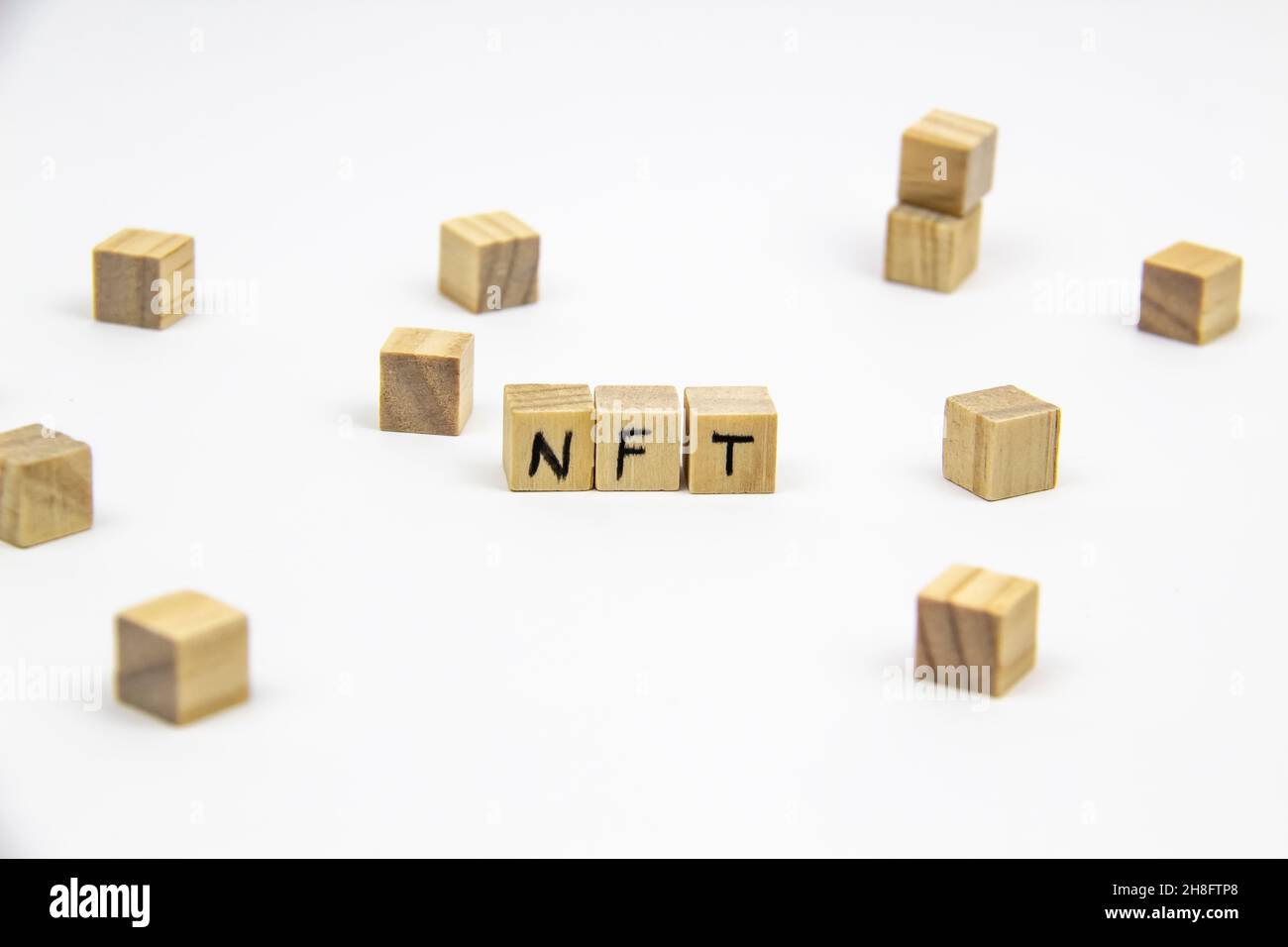 Word NFT (non fungible token) written on the wood cubes on white  background. Non-fungible tokens  concept NFT. Stock Photo