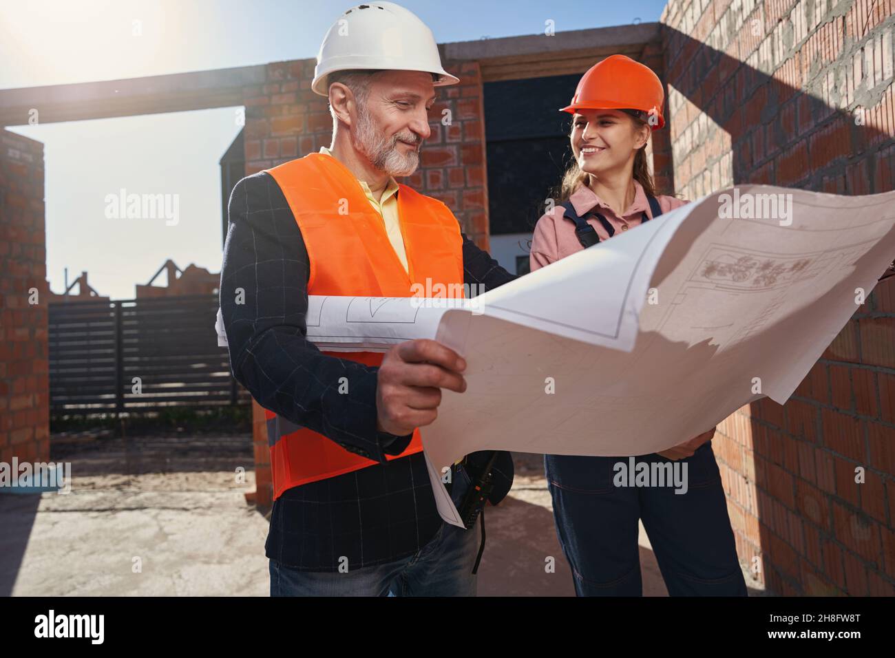 Two certified engineers looking happy about the building process Stock Photo