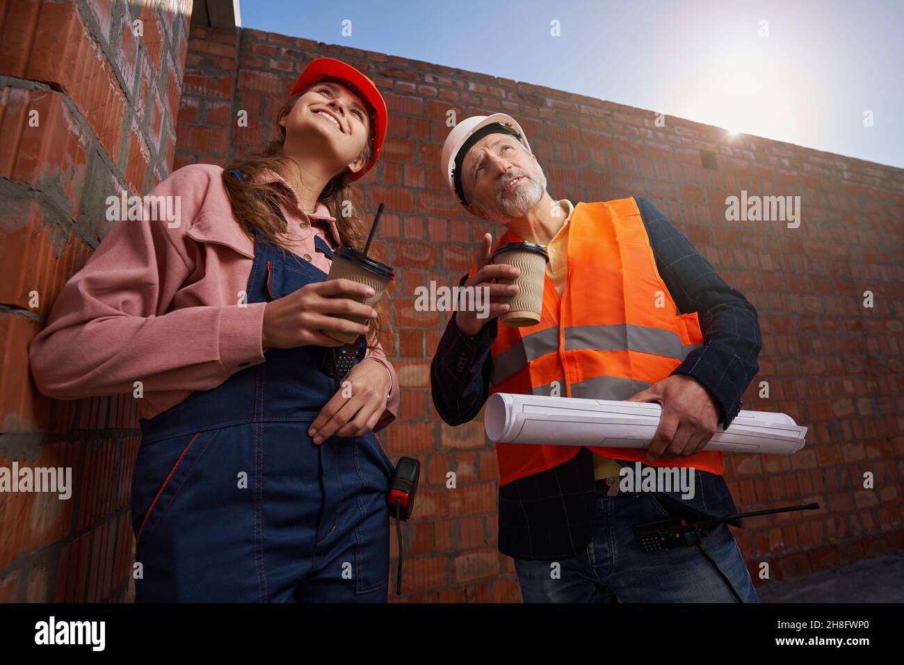 Inspired architects having coffee and looking at the construction site Stock Photo