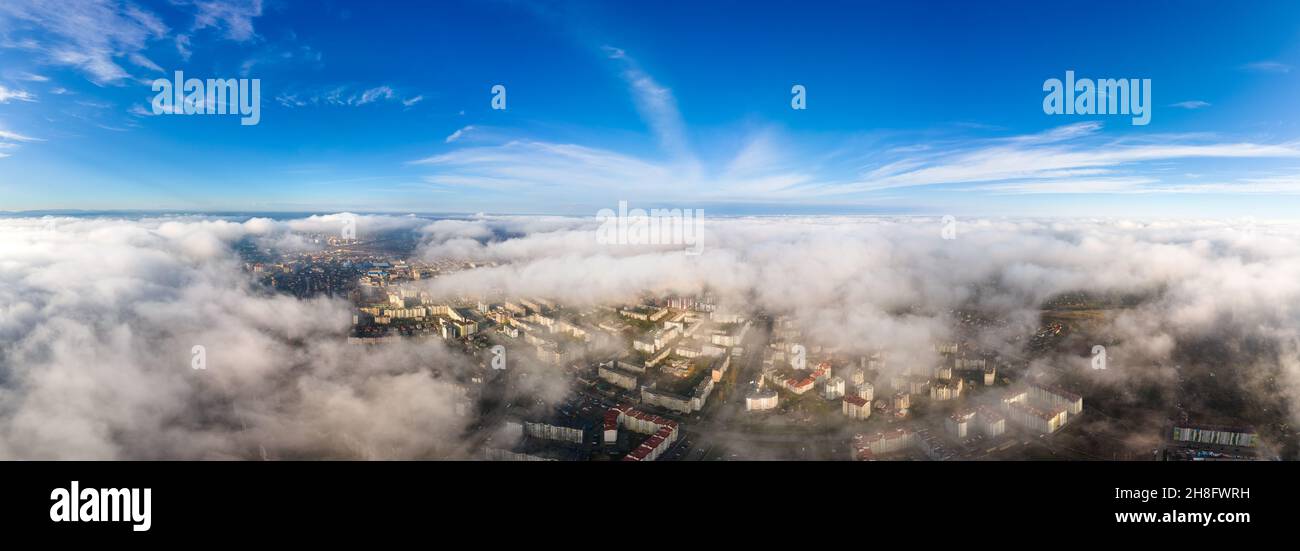 Top aerial view of fluffy white clouds over modern city with high rise ...