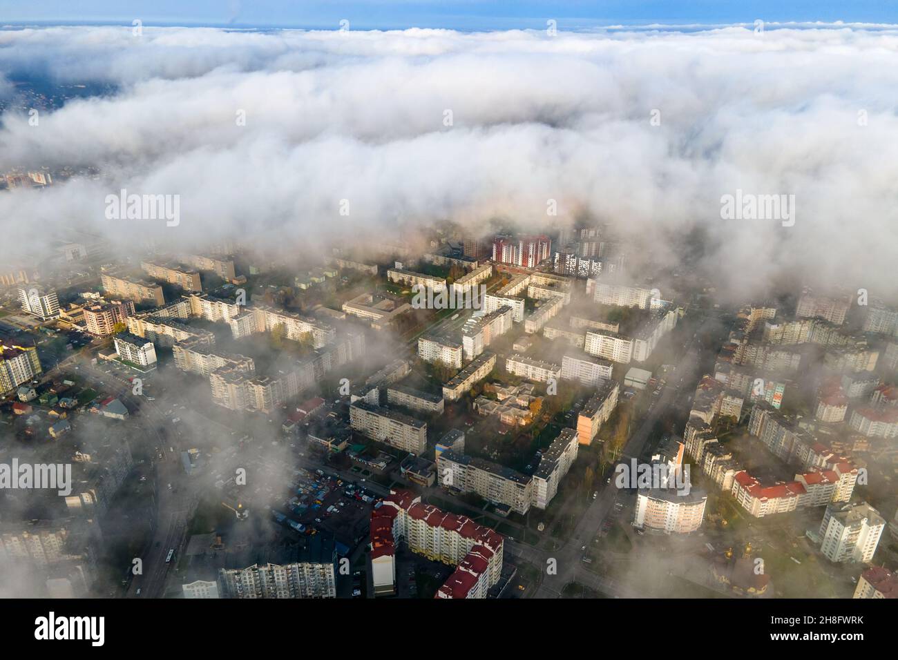 Top aerial view of fluffy white clouds over modern city with high rise ...