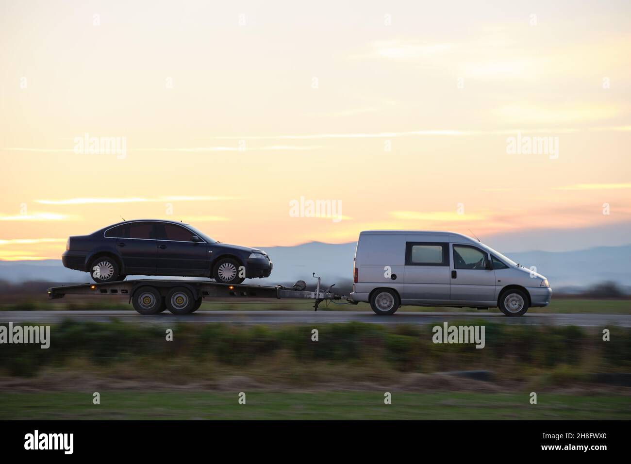 Tow truck vehicle with car transporting carrier trailer driving on ...