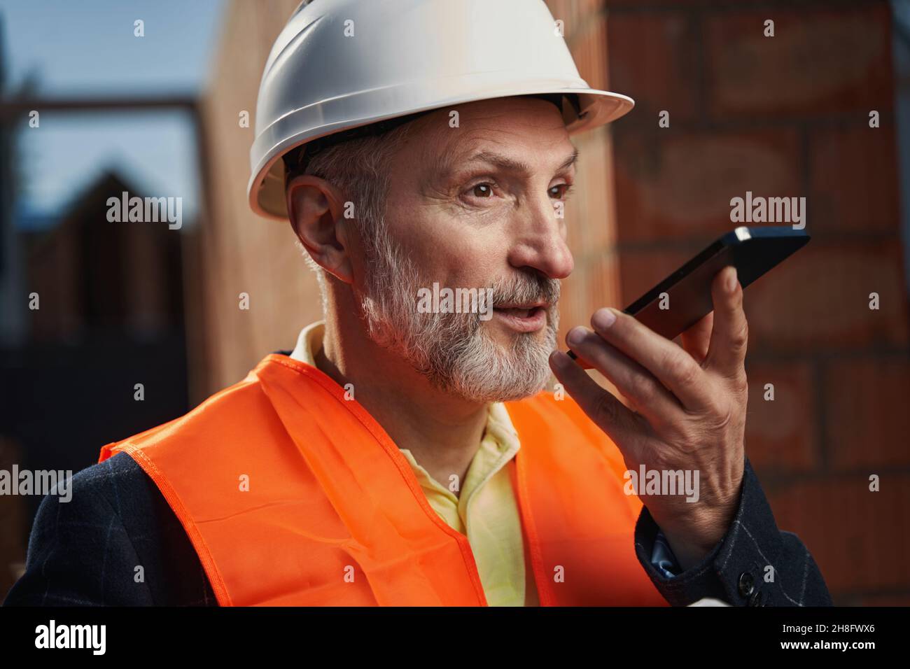 Professional builder having a busy conversation on the phone Stock Photo
