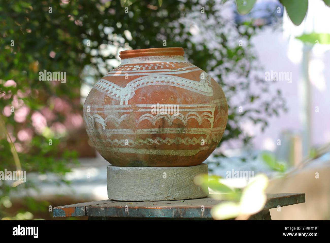 https://c8.alamy.com/comp/2H8FX1K/close-up-photo-shot-of-a-water-pot-made-of-clay-kept-in-the-open-outside-and-hand-painted-white-design-on-it-2H8FX1K.jpg