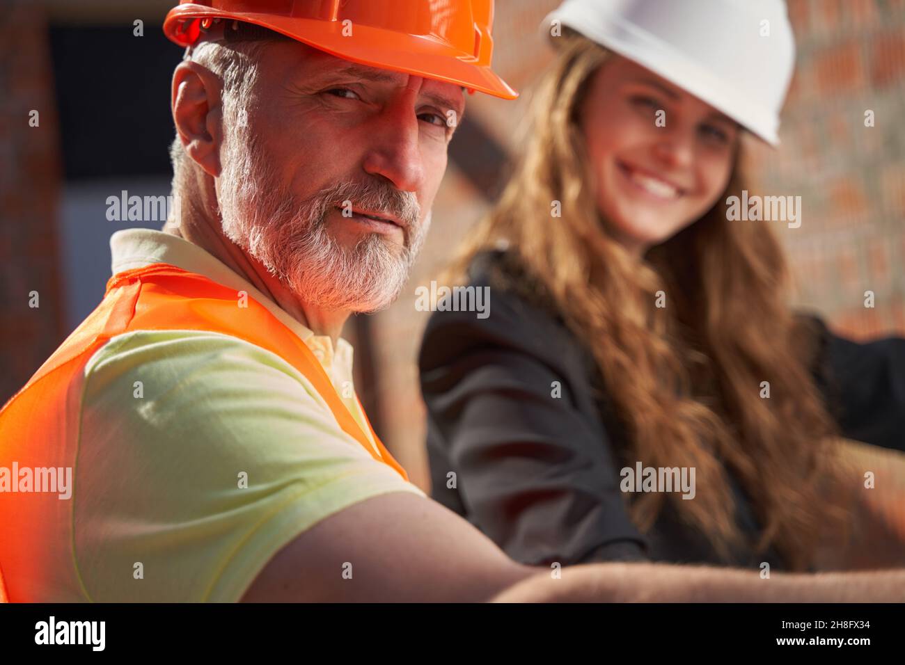 Two construction site workers smiling and posing for camera Stock Photo