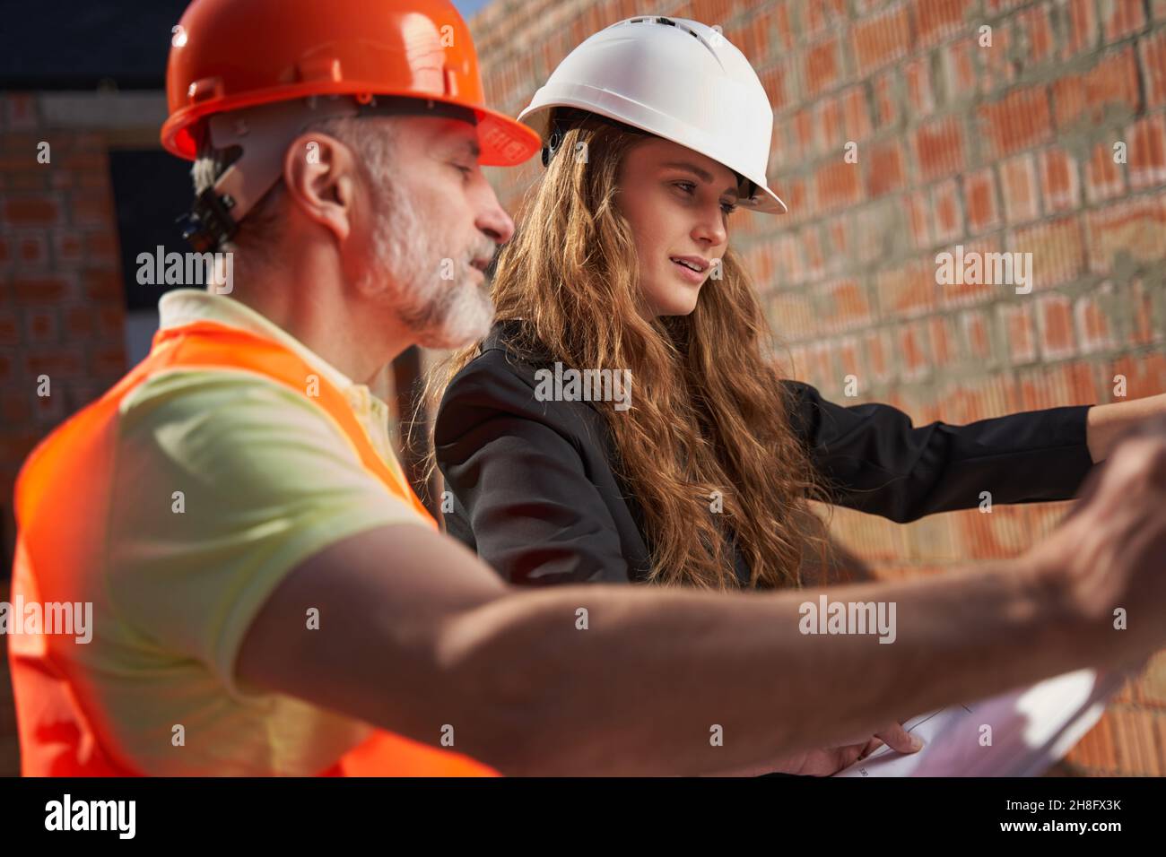 Concetrated construction site workers studying the building plans Stock Photo